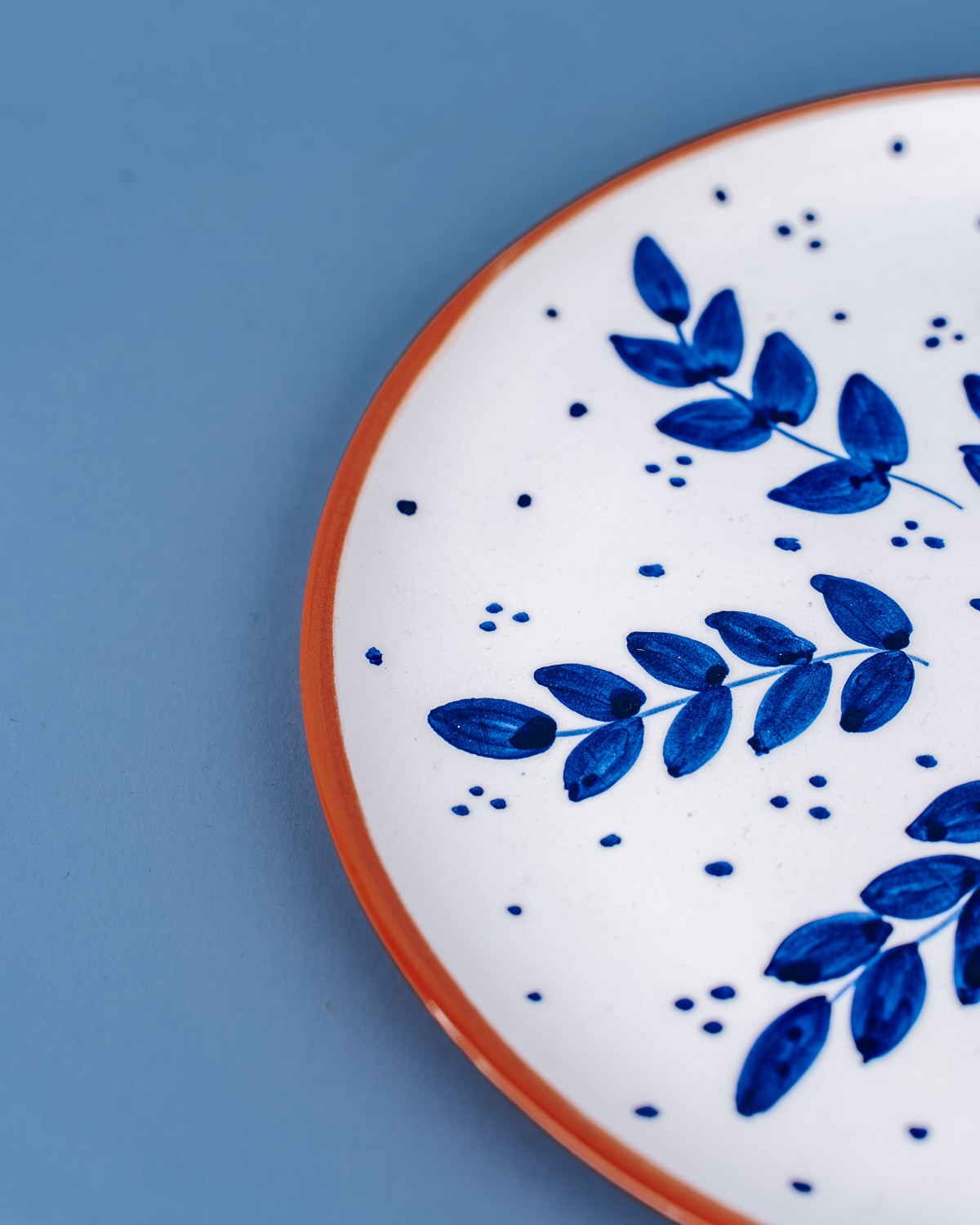 Håndlavet frokosttallerken i terracotta keramik med blå blade